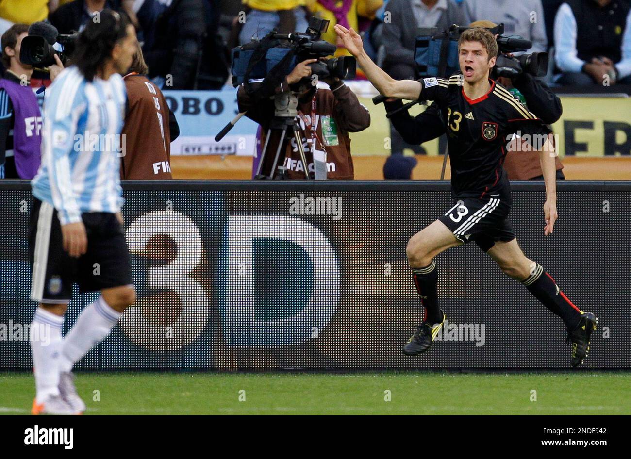 Germany's Thomas Mueller, right, reacts after scoring a goal during the World Cup quarterfinal soccer match between Argentina and Germany at the Green Point stadium in Cape Town, South Africa, Saturday, July 3, 2010. (AP Photo/Matt Dunham) Stockfoto