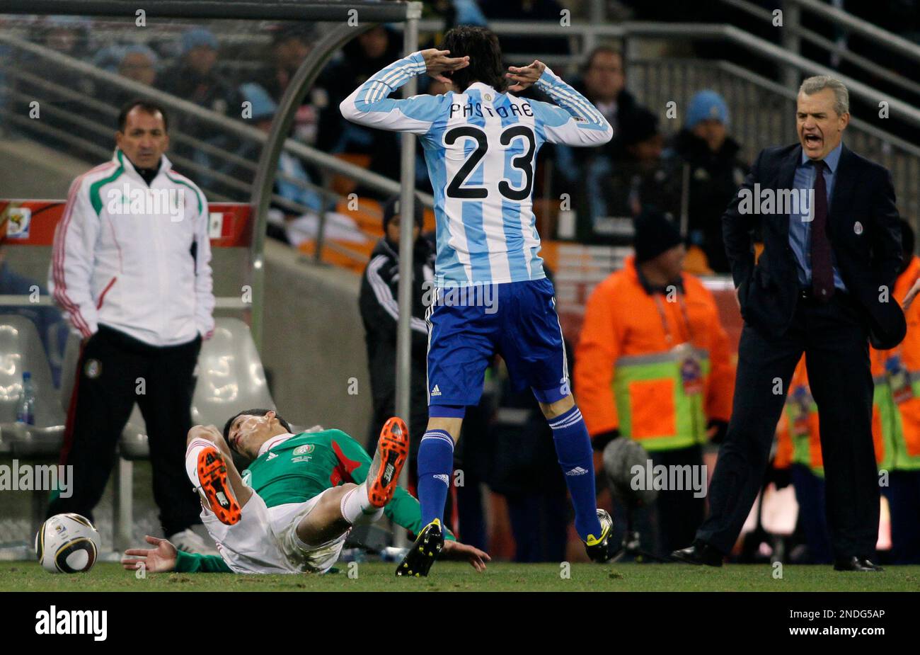 Argentina's Javier Pastore, center, tackles Mexico's Guillermo Franco, left, during the World Cup round of 16 soccer match between Argentina and Mexico at Soccer City in Johannesburg, South Africa, Sunday, June 27, 2010. Standing right is Mexico head coach Javier Aguirre. (AP Photo/Ivan Sekretarev) Stockfoto