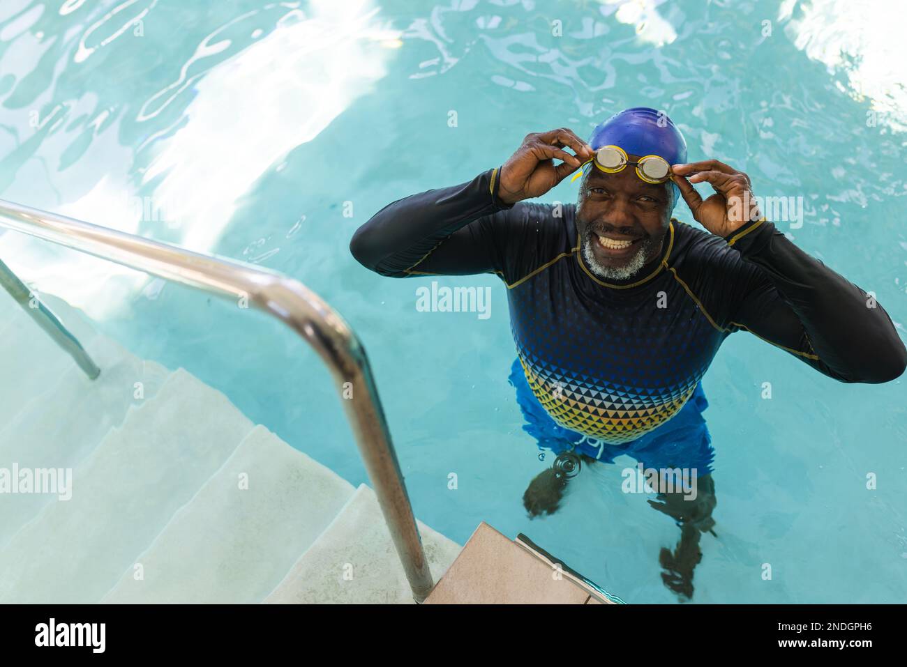 Porträt eines afroamerikanischen Seniorenmannes mit Badebrille im Schwimmbad. Altersruhestandsleben und Lebenskonzept Stockfoto