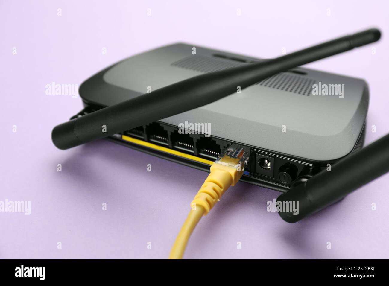 Moderner WLAN-Router im lilafarbenen Hintergrund, Nahaufnahme Stockfoto