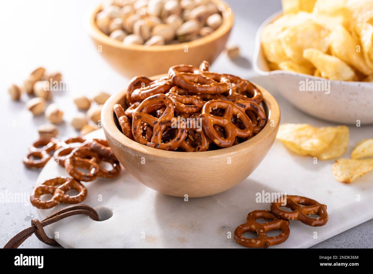 Auswahl an salzigen Snacks auf dem Tisch mit Brezeln, Pistazien und Kartoffelchips, Snacks, die gut zu Bier passen Stockfoto