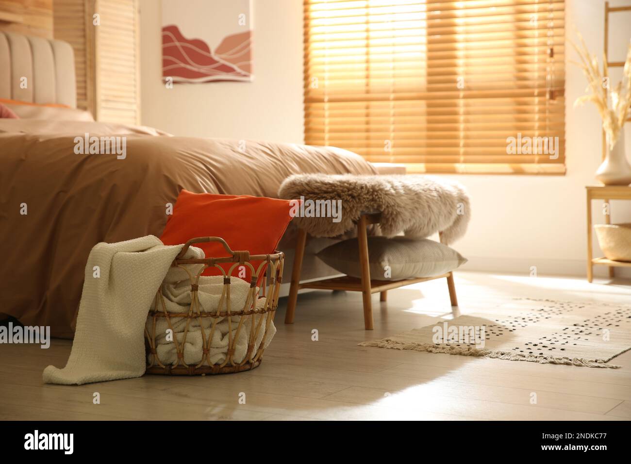 Innenausstattung des Schlafzimmers mit Bett, Korb und Bank Stockfoto