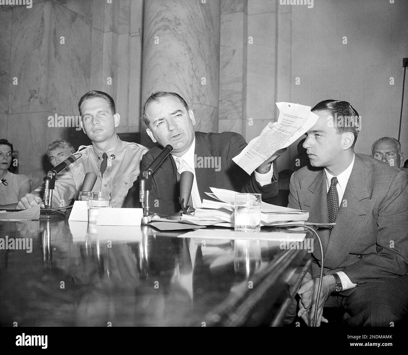 Senator Joseph McCarthy (R-Wis), waves a copy of a monitored telephone call between Pvt. G. David Schine, left, and Secretary of the Army Stevens at session of the McCarthy-Army dispute hearing on June, 7, 1954. Roy M. Cohn, sitting with them, has not finished his testimony but is excused from the stand temporarily while the phone calls are read into the record. (AP Photo) Stockfoto