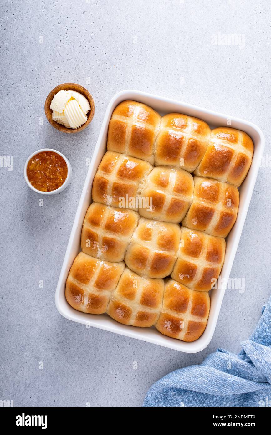Traditionelle Brötchen mit heißem Kreuz, frisch gebacken für den Osterbrunch in einer Pfanne Stockfoto