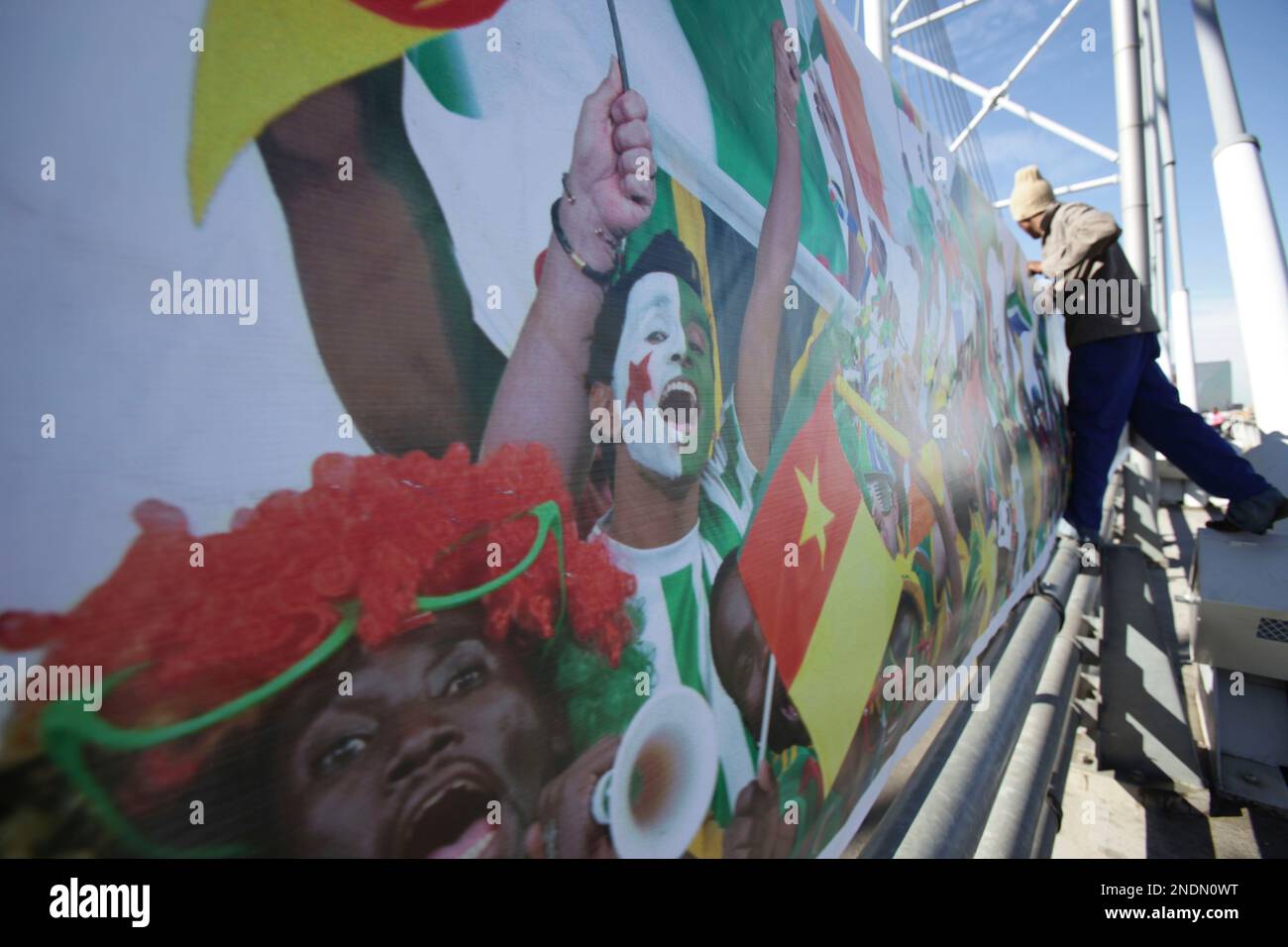 A worker installs a banner on the Nelson Mandela bridge leading in to