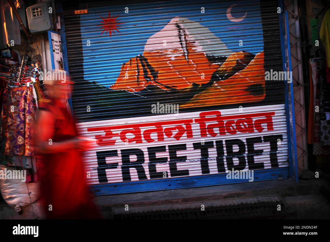 In This May 10 2010 Photograph A Tibetan Buddhist Monk Walks Past A in-this-may-10-2010-photograph-a-tibetan-buddhist-monk-walks-past-a