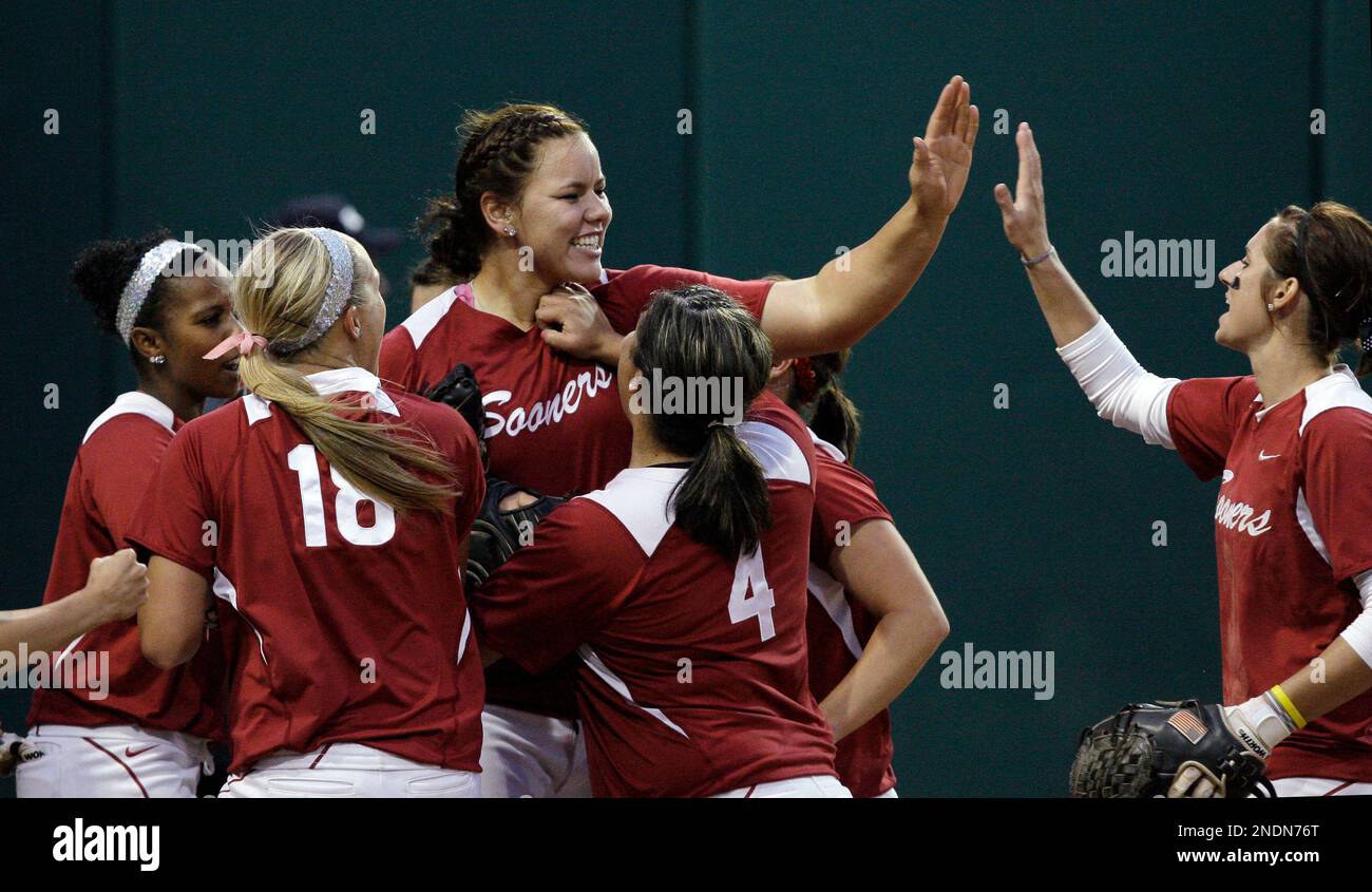 Oklahoma starting pitcher Keilani Ricketts, center, is surrounded by teammates congratulating her after she got out of the fourth inning without allowing a run to Washington in an NCAA super regional softball game Thursday, May 27, 2010, in Seattle. (AP Photo/Elaine Thompson) Stockfoto