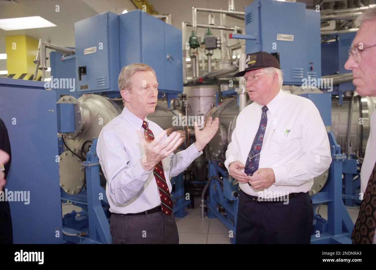 California Gov. Pete Wilson, left, talks with George Hallinan of Rockwell International’s Rocketdyne plant during a tour of a new building dedicated to production of the Space Station Freedom at the facility in Canoga Park, Los Angeles, March 20, 1993. Behind them is a thermal vacuum chamber, designed to subject space station component to the vacuum and temperature conditions of space. (AP Photo/Reed Saxon) Stockfoto
