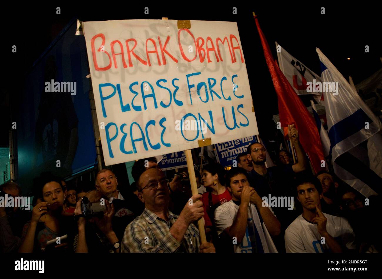 Israeli left wing activists hold flags and signs as they participate in a rally against West Bank Jewish settlements, in Jerusalem, Saturday, May 15, 2010. (AP Photo/Sebastian Scheiner) Stockfoto