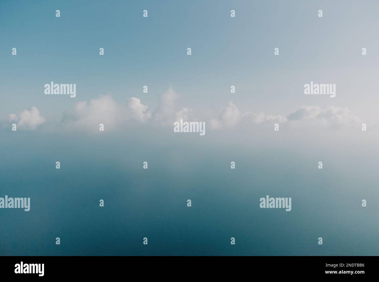 Blauer Himmel mit weißen Wolken über ruhigem Sommerpanorama des Meeres. Draufsicht der Drohne. Abstrakte Luft Natur Sommer Ozean Sonnenuntergang Meer und Himmel Hintergrund Stockfoto