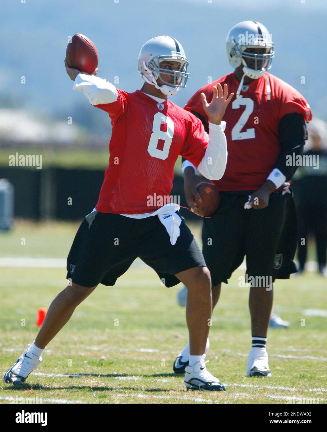 Oakland Raiders' quarterback Jason Campbell (8) passes as teammate JaMarcus Russell (2) looks on during rookie football mini-camp, Friday, April 30, 2010, in Alameda, Calif. (AP Photo/Ben Margot) Stockfoto