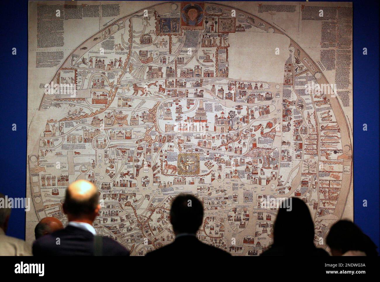 Visitors look at a photographic reconstructed 1300 map 'Brunswick and the World' by Ebstorf on display in an exhibition 'Magnificent Maps, Power, Propaganda and Arts' at the British Library in London, Thursday, April 29, 2010. The Ebstorf world map, the largest known medieval mappa mundi was destroyed by Allied bombs in 1943, shows the world as the body of Christ with his arms and feet emerging from the map. (AP Photo/Sang Tan) Stockfoto