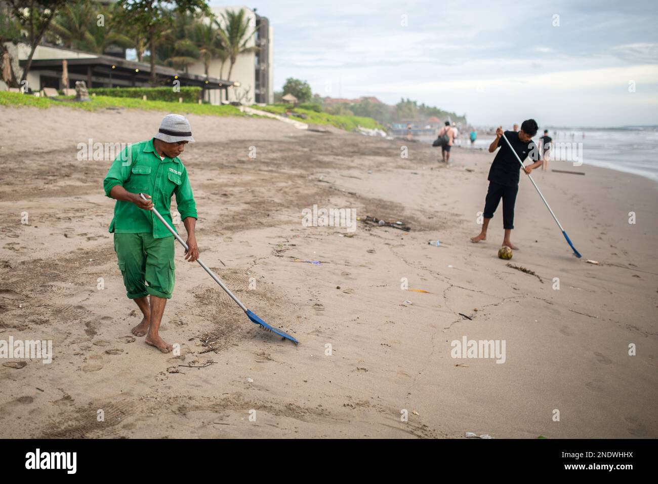 Bali, Indonesien - 15. Februar 2023: Unbekannte Männer, die den Strand in Bali, Indonesien, säubern. Stockfoto