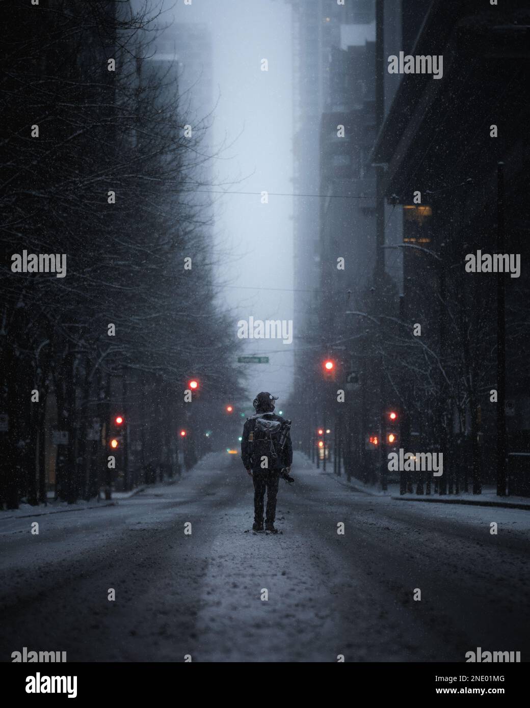 Mann, der während eines Schneesturms mitten auf der Straße steht Stockfoto
