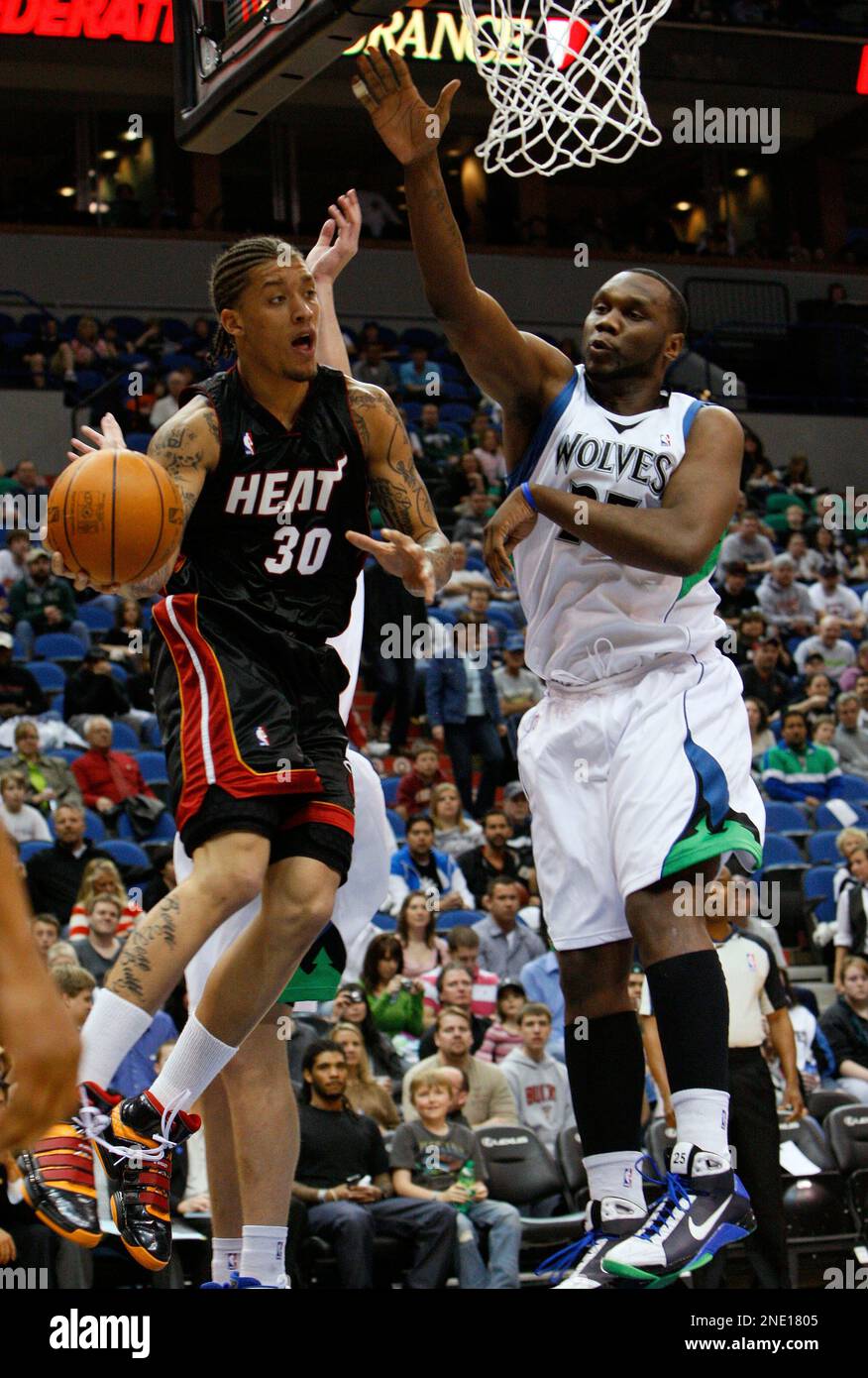 Miami Heat forward Michael Beasley (30) passes to a teammate under pressure from Minnesota Timberwolves forward Al Jefferson, right, during the first quarter of an NBA basketball game in Minneapolis, Saturday, April 3, 2010. (AP Photo/Ann Heisenfelt) Stockfoto