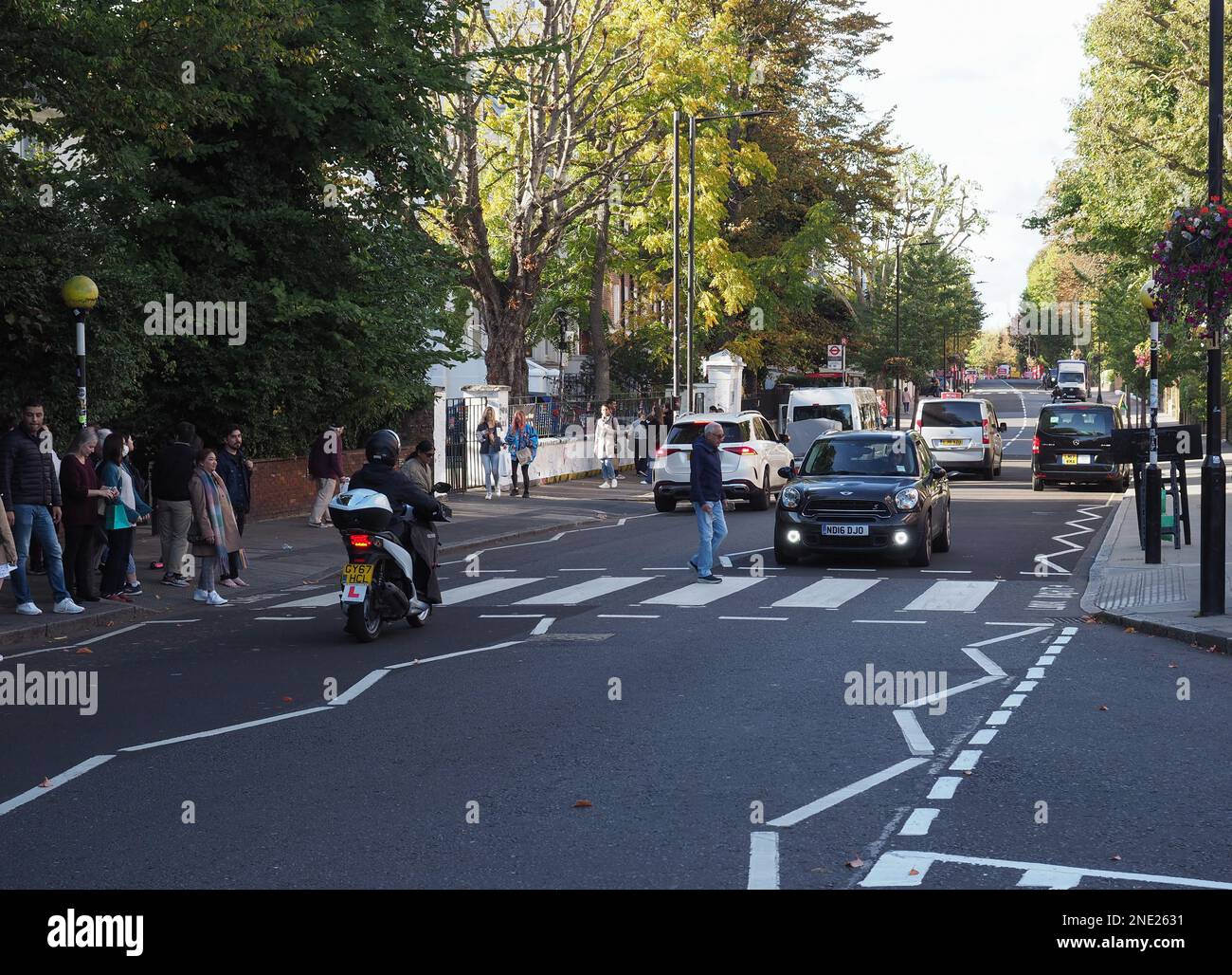 LONDON, Großbritannien - CA. 2022. OKTOBER: Die Bewohner der Abbey Road überqueren die Zebra-Kreuzung, die durch das Album der Beatles 1969 berühmt wurde Stockfoto