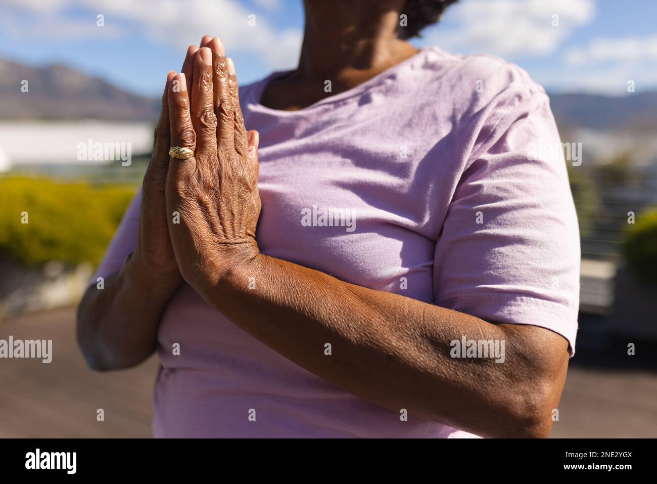 Eine afroamerikanische Seniorin, die auf der Terrasse meditiert. Altersruhestandsleben und Lebenskonzept Stockfoto