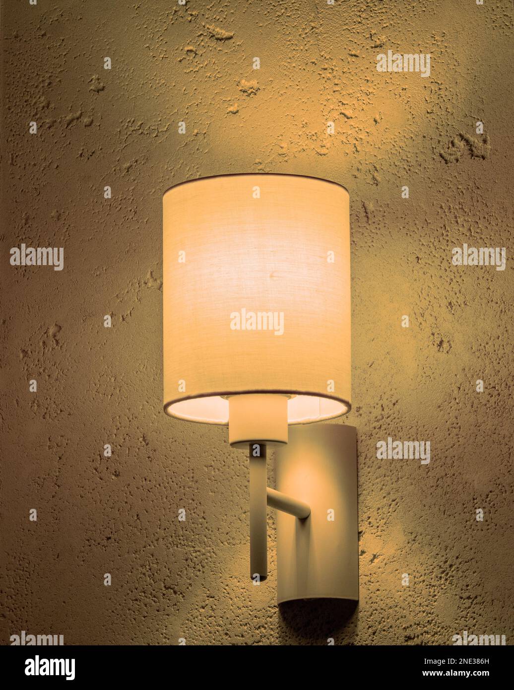 Wandlaterne mit orangefarbenem Lampenschirm beleuchtet Retro-Stuck. Stockfoto