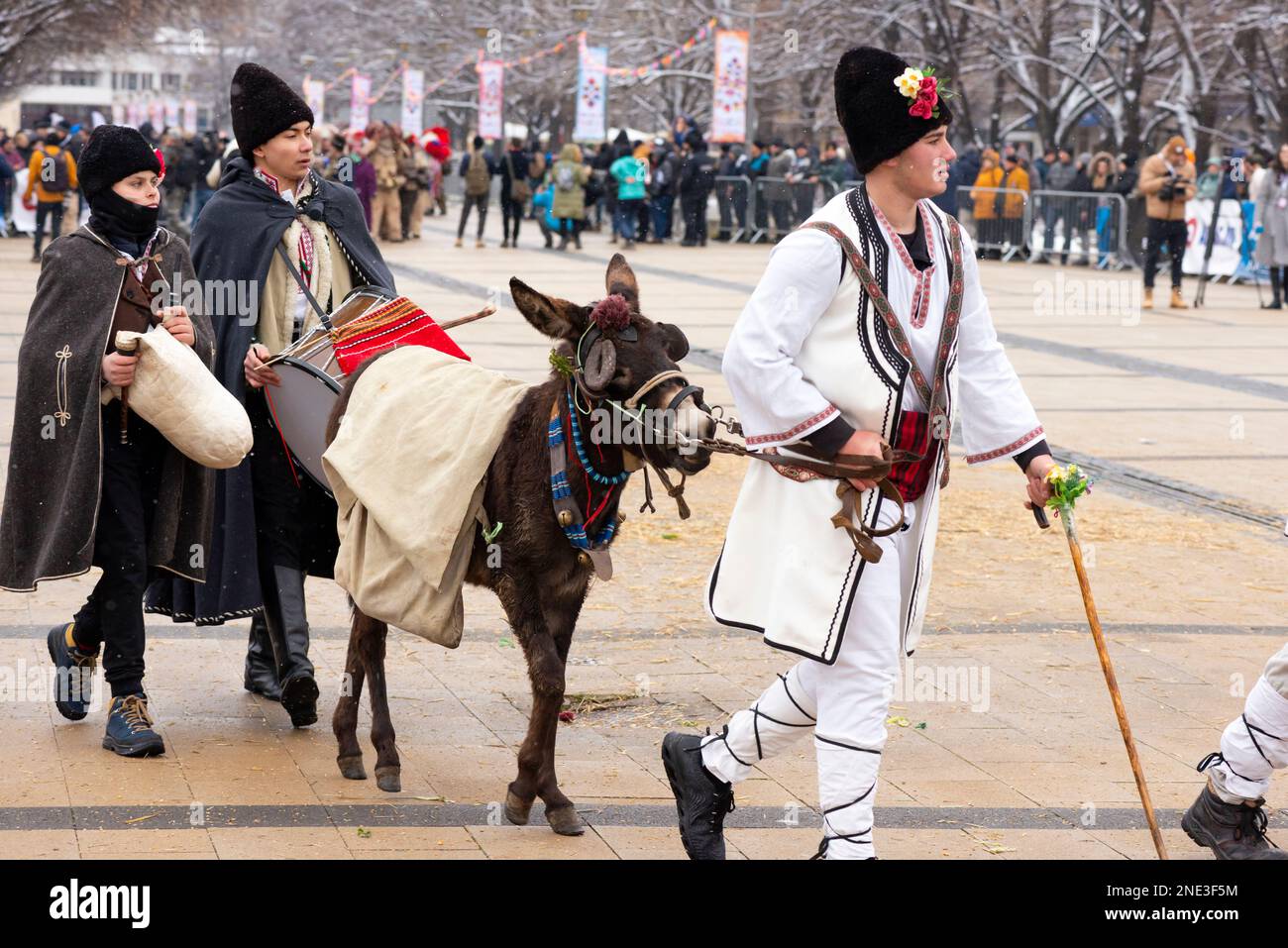 Teilnehmer traditioneller Volkskleidung und ein Esel beim Surva International Masquerade and Mummers Festival in Pernik, Bulgarien, Osteuropa Stockfoto
