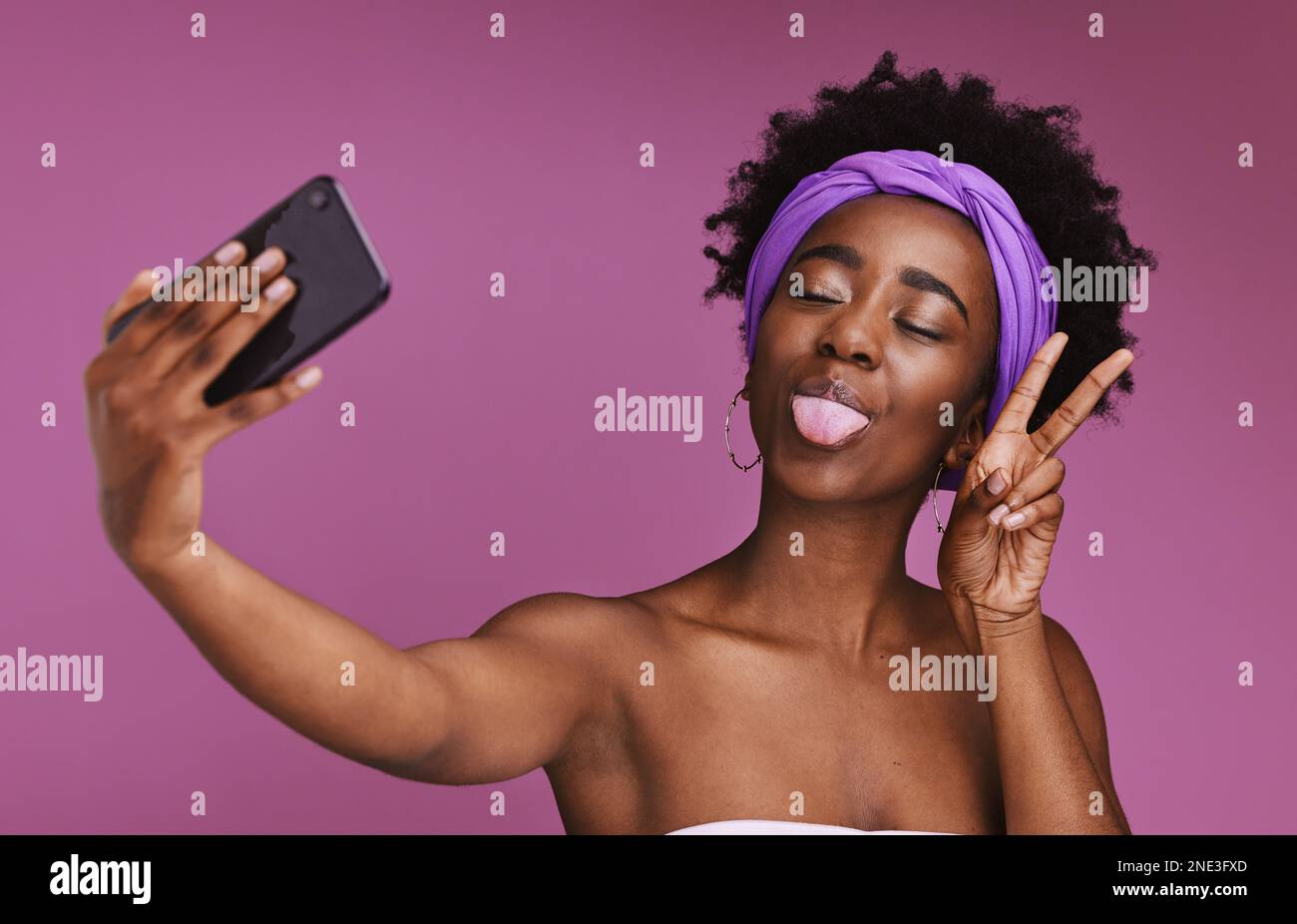 Telefon, Selfie und Gesicht einer schwarzen Frau mit Friedenszeichen für Wellness, Mode und Kosmetik auf lila Hintergrund. Schönheit, Hautpflege und Beeinflussung von Mädchen Stockfoto
