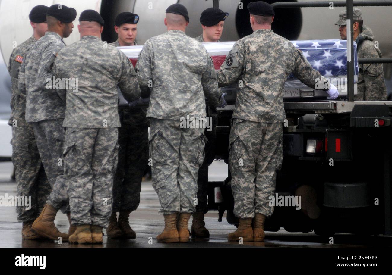 An Army carry team lifts a transfer case containing the remains of Spc ...