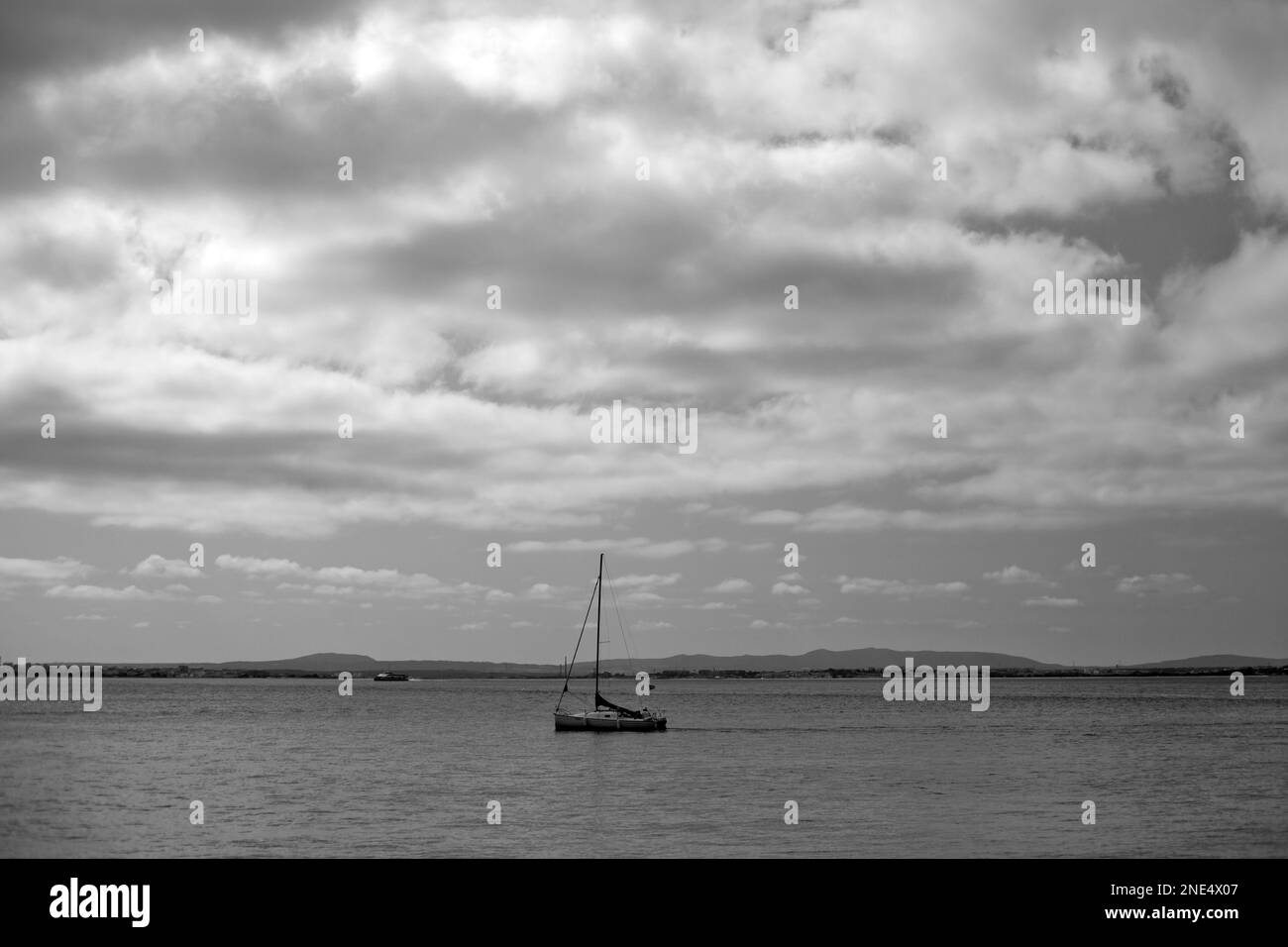 Schwarzweißfoto von Booten in der Bucht von Sesimbra an einem bewölkten Morgen. Stockfoto