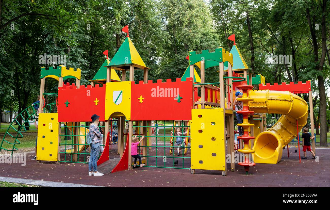 Farbenfroher Spielplatz mit Kindern und Eltern im Park. Stockfoto