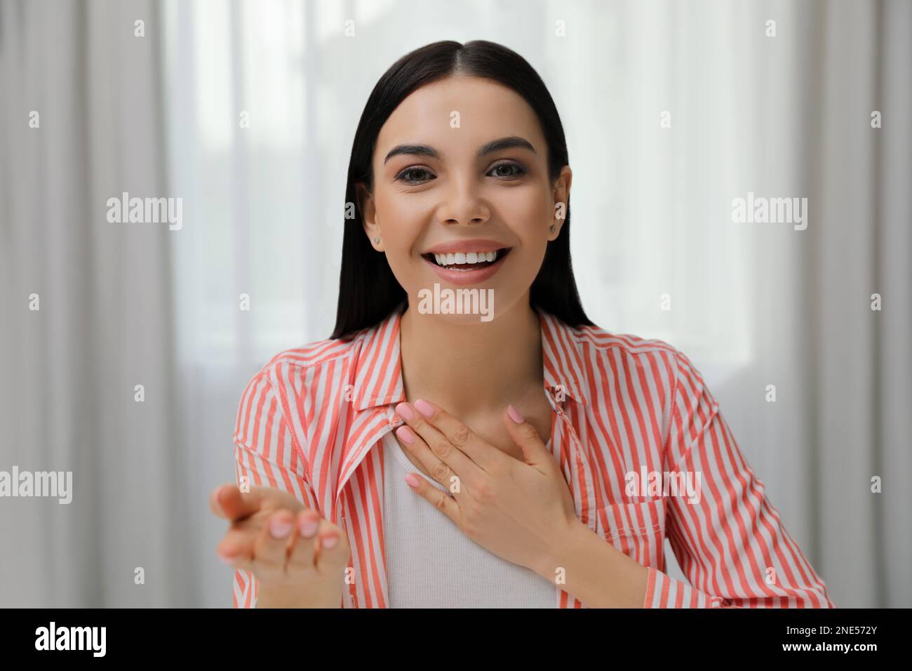 Schöne junge Frau, die ein Webinar im Raum veranstaltet, Kameraansicht Stockfoto