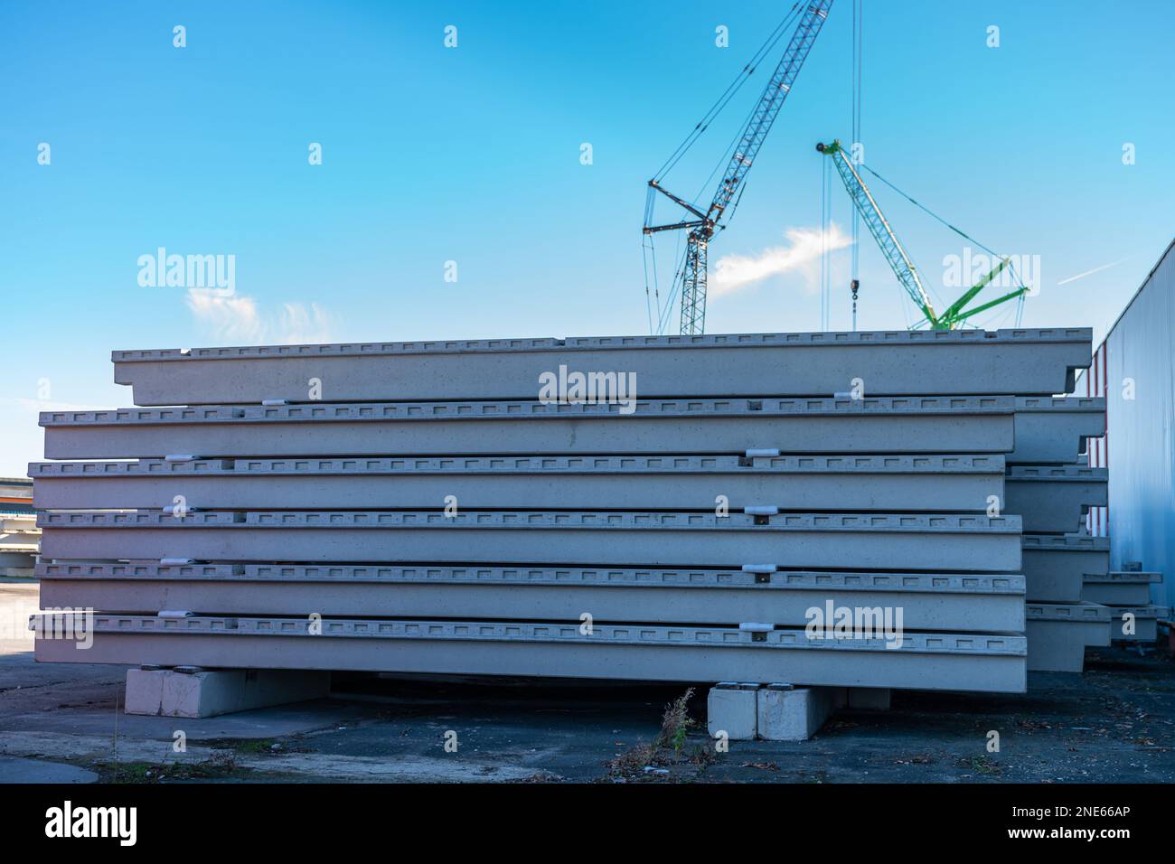 Betonplatten auf Baustellen gestapelt. Turmkräne im Hintergrund. Stockfoto