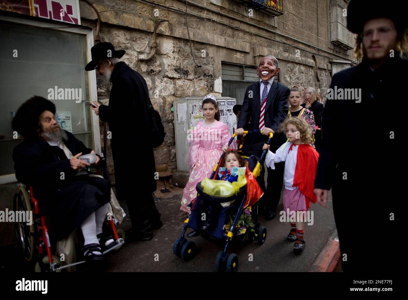 An ultra-Orthodox Jewish man dressed up as US President Barack Obama walks with his family during the Purim holiday in Jerusalem, Monday, March 1, 2010. The Jewish holiday of Purim celebrates the Jews' salvation from genocide in ancient Persia, as recounted in the Scroll of Esther. (AP Photo / Oded Balilty) Stockfoto