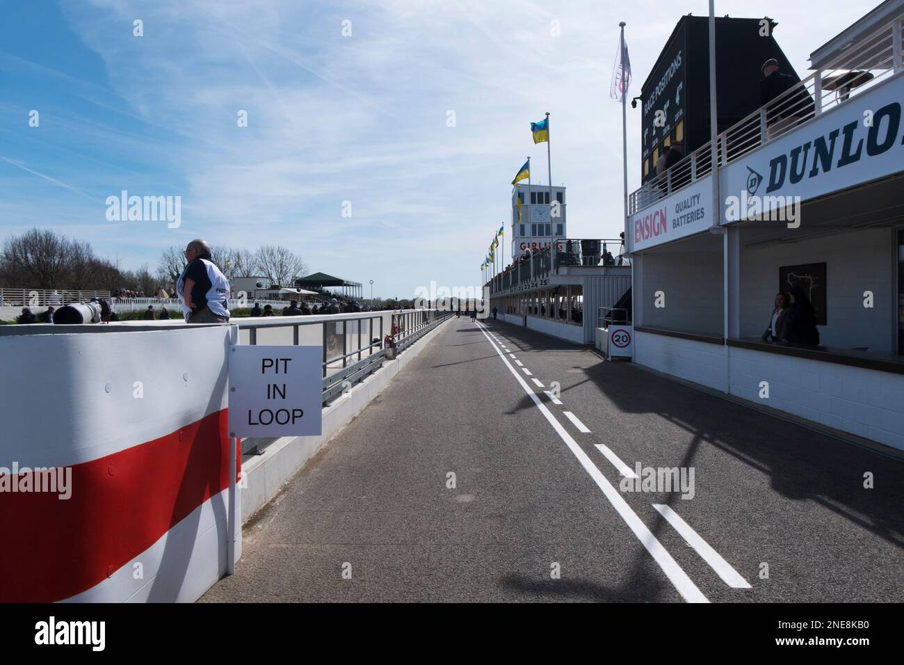 Ein Fotograf steht am Eingang der Boxengasse beim 79. Members' Meeting, Goodwood Motor Racing Circuit, Chichester, West Sussex, Großbritannien Stockfoto