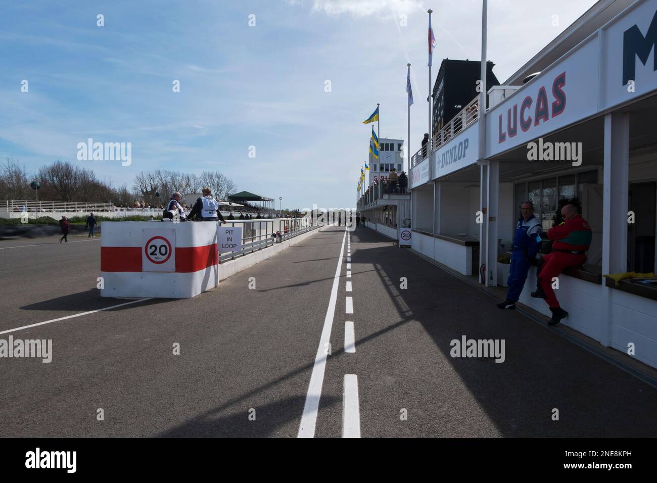Fahrer sitzen an der Boxenwand am Eingang zur Boxengasse beim 79. Mitgliedertreffen, Goodwood Motor Racing Circuit, Chichester, West Sussex, Stockfoto
