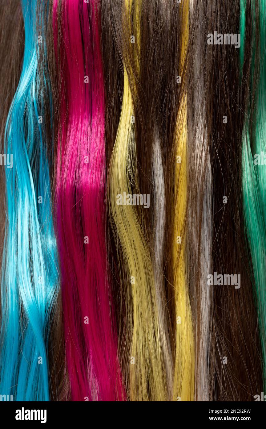Set aus bunten langen Haarfäden auf dunkelbraunem Hintergrund Stockfoto