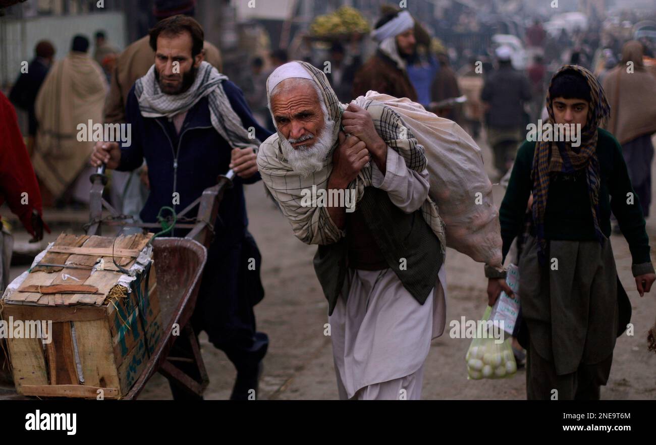 Pakistanis are seen at a wholesale market in Rawalpindi, Pakistan, Friday, Feb. 19, 2010. (AP Photo/Muhammed Muheisen) Stockfoto
