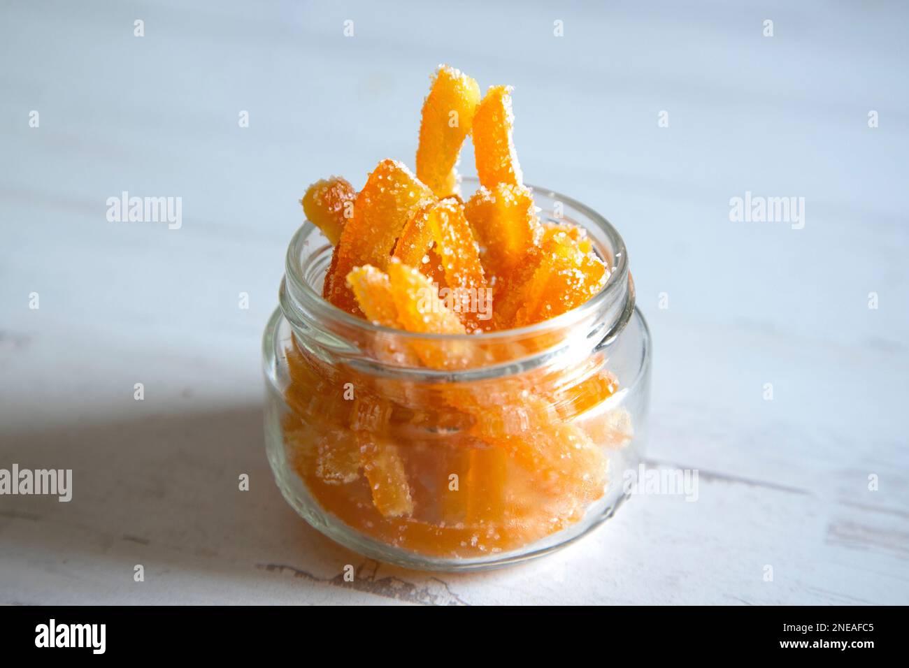 Kandierte Orangenstäbchen in Zucker, serviert in einem Glas. Stockfoto