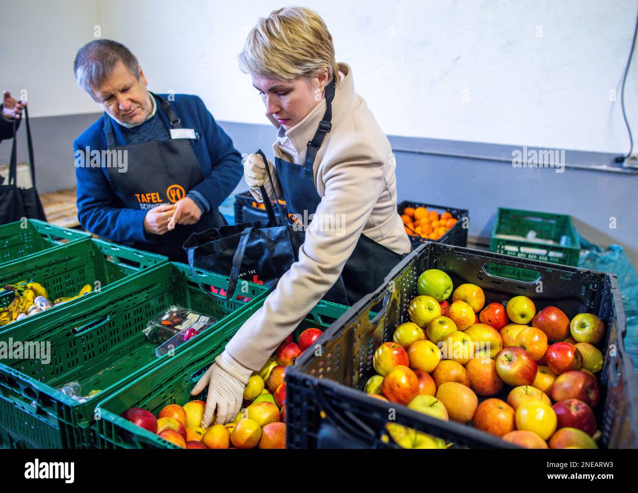 Schwerin, Deutschland. 16. Februar 2023. Manuela Schwesig (SPD, r), Ministerpräsidentin von Mecklenburg-Vorpommern, steht neben Peter Grosch (l), Schweriner Tafel. Schwesig hilft Freiwilligen an der Schweriner Tafel beim Sortieren und Verpacken von Essen. Die Ministerpräsidentin betont die Bedeutung sozialer Institutionen in Krisenzeiten und dankt den dort tätigen Freiwilligen. Angesichts der derzeit hohen Inflation kommt den staatlichen Lebensmittelbanken eine besondere Rolle zu, wenn es darum geht, einkommensschwache Haushalte mit Grundnahrungsmitteln auszustatten. Kredit: Jens Büttner/dpa/Alamy Live News Stockfoto