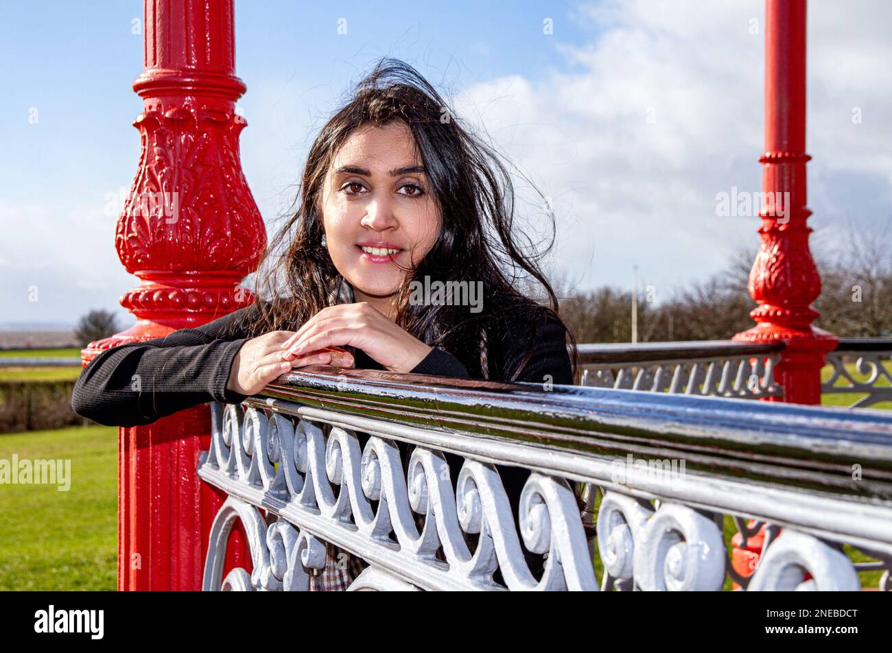 Eine wunderschöne und modische Frau verbringt den Tag damit, dass sie an einem sehr windigen Tag in Schottland, Großbritannien, entlang Dundee's Riverside fotografiert wird Stockfoto