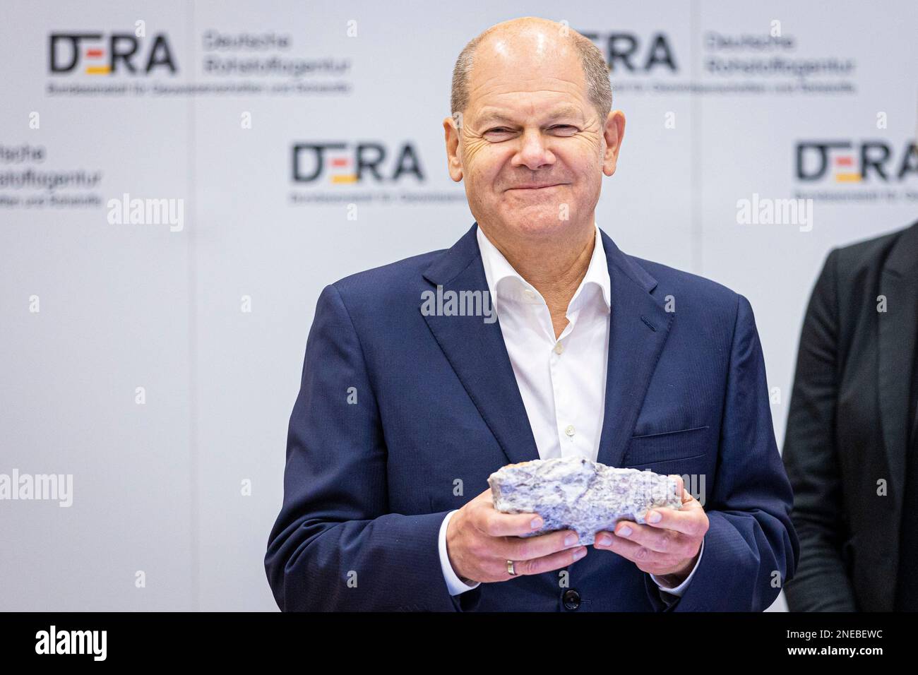Hannover, Deutschland. 16. Februar 2023. Bundeskanzler Olaf Scholz (SPD) hält während seines Besuchs beim Bundesinstitut für Geowissenschaften und Naturressourcen (BGR) Lithiumerz in seinen Händen. Im Mittelpunkt der Begehung steht die Frage der Situation der Rohstoffversorgung in Deutschland. Kredit: Moritz Frankenberg/dpa/Alamy Live News Stockfoto