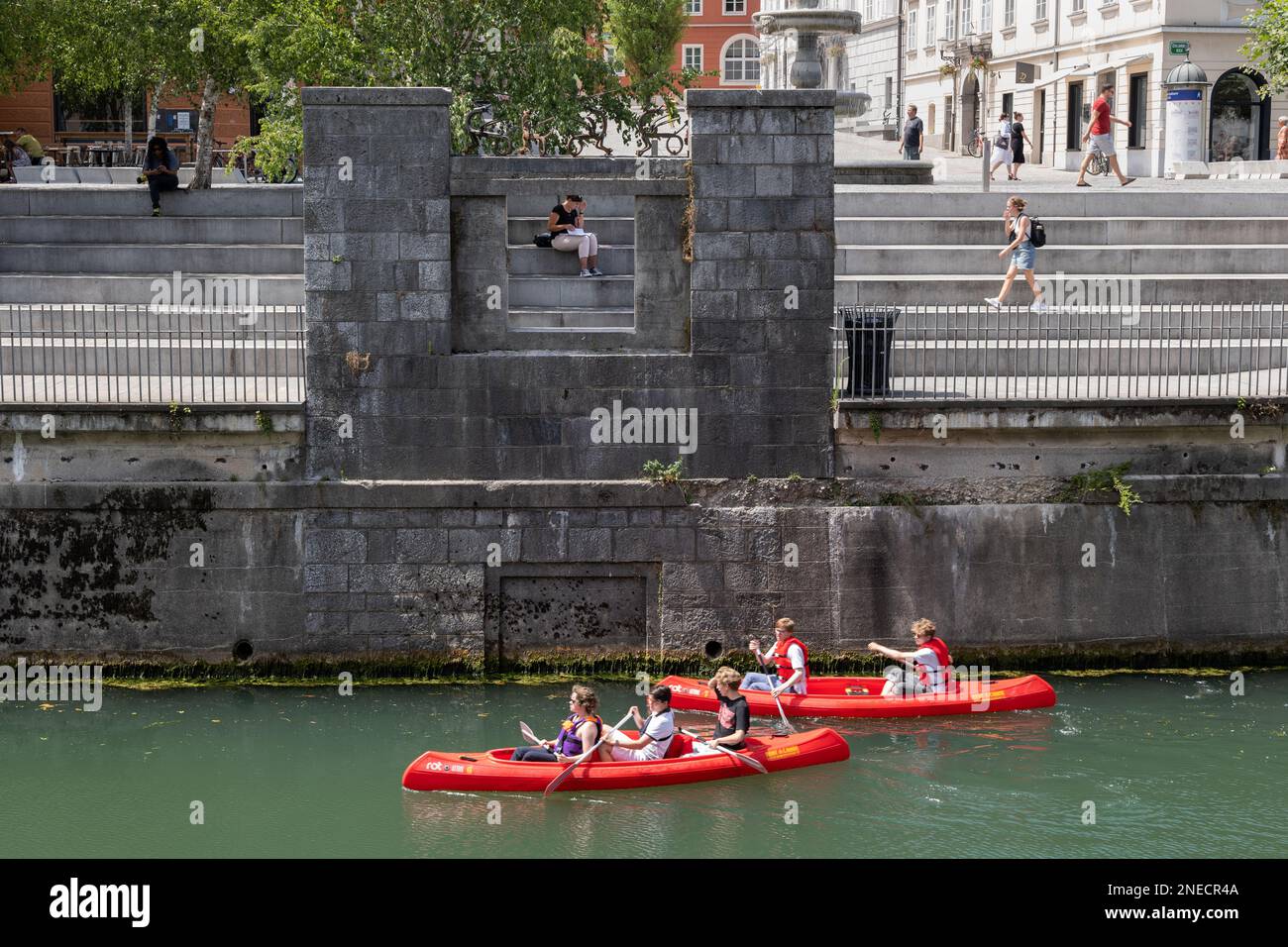 Die Stadt Ljubljana, Slowenien, Kajakfahrer auf dem Fluss Ljubljanica am Ufer des New Square (Novi Trg), Kajak- oder Kanufahrten sind ein beliebter Tourist Stockfoto