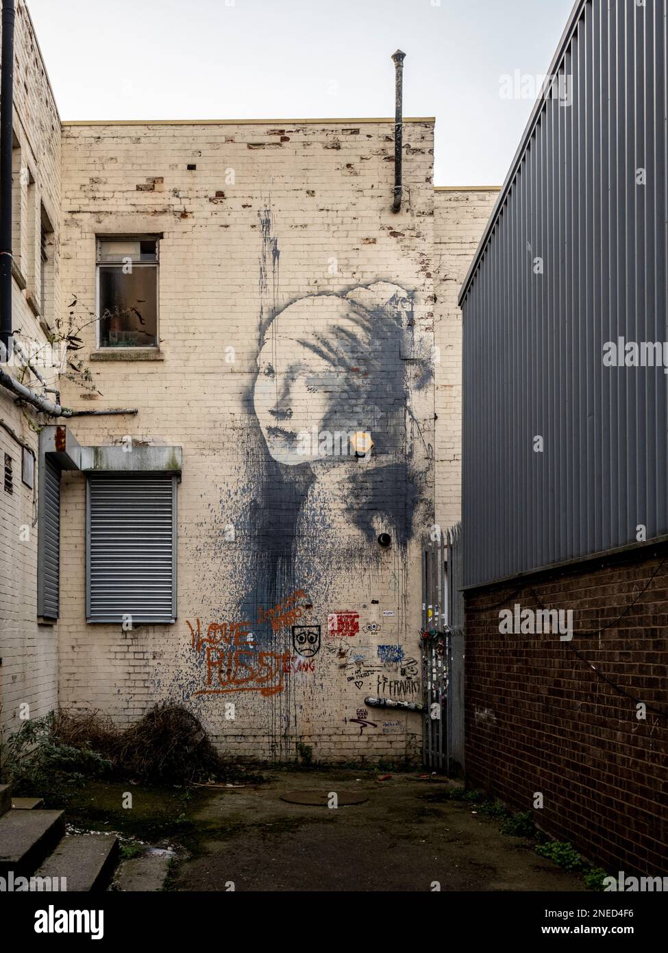 Banksy Bristol Gasse Graffiti Mural The Girl mit dem durchbohrten Trommelfell inspiriert von Vermeer's Girl mit einem Perlenohrring. Bristol. UK Stockfoto