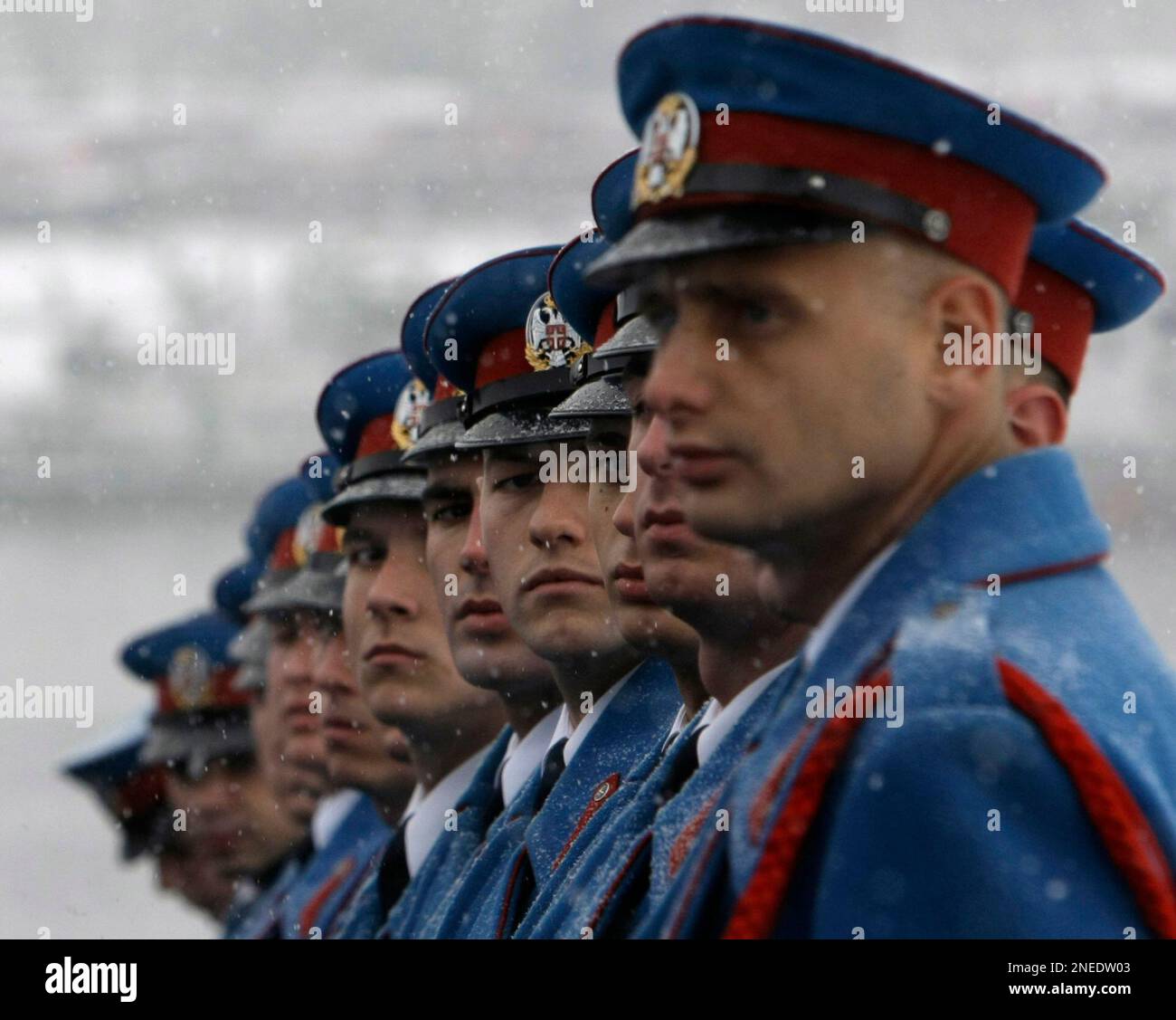 A Serbian military honor guard pay homage to the victims of the