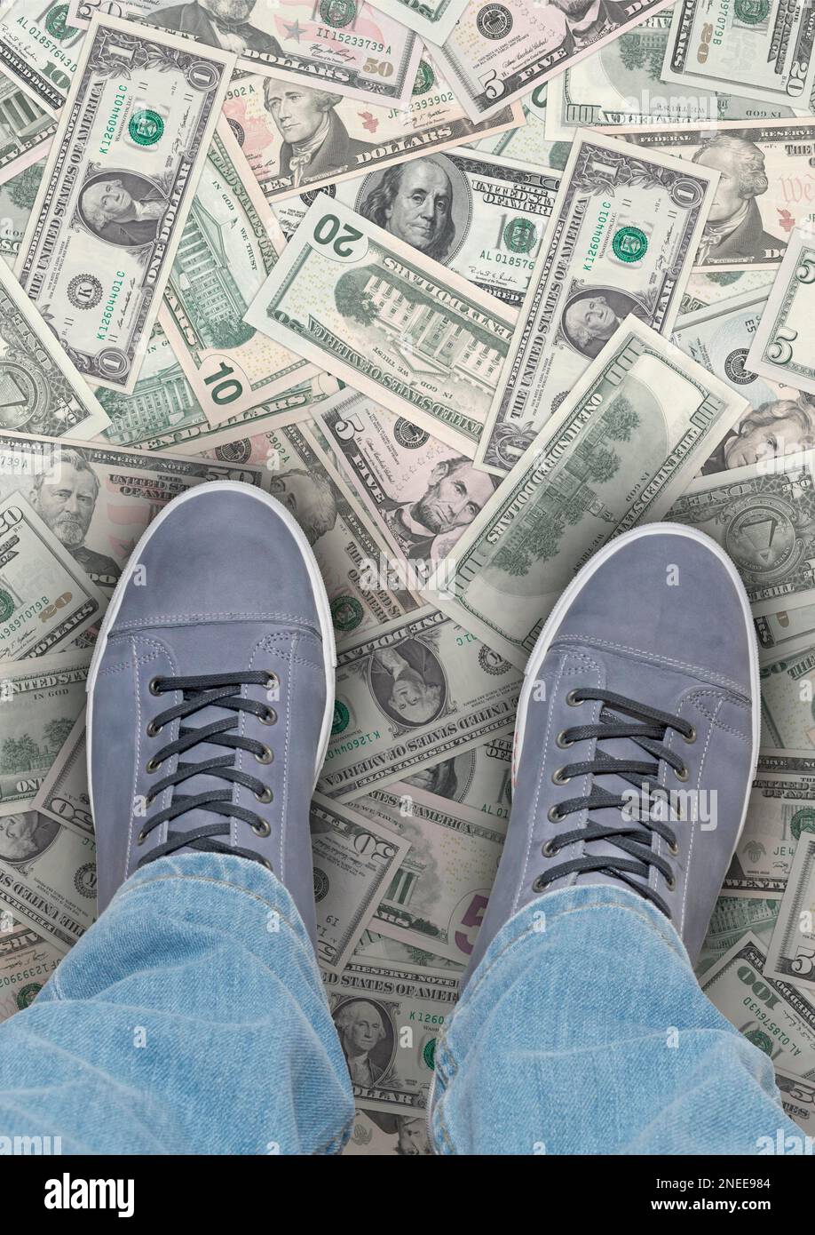 Das Geld liegt auf der Straße. Eine Person steht auf US-Dollar-Banknoten im Porträtformat Stockfoto