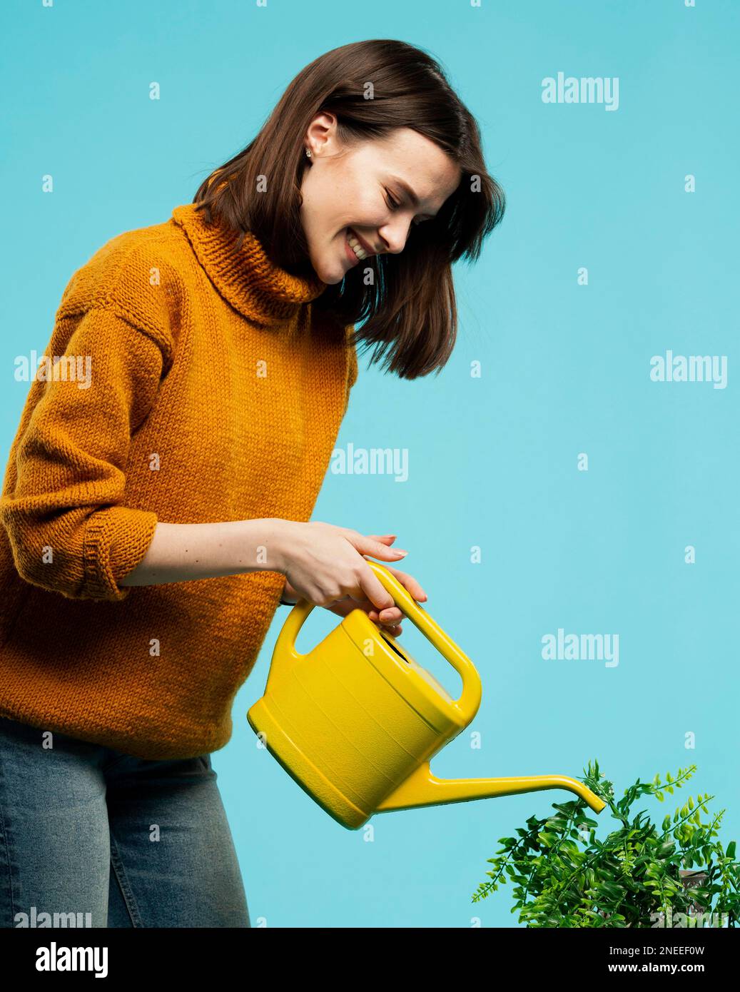 Frau mit mittlerer Schussaufnahme und Gießkannne Stockfoto