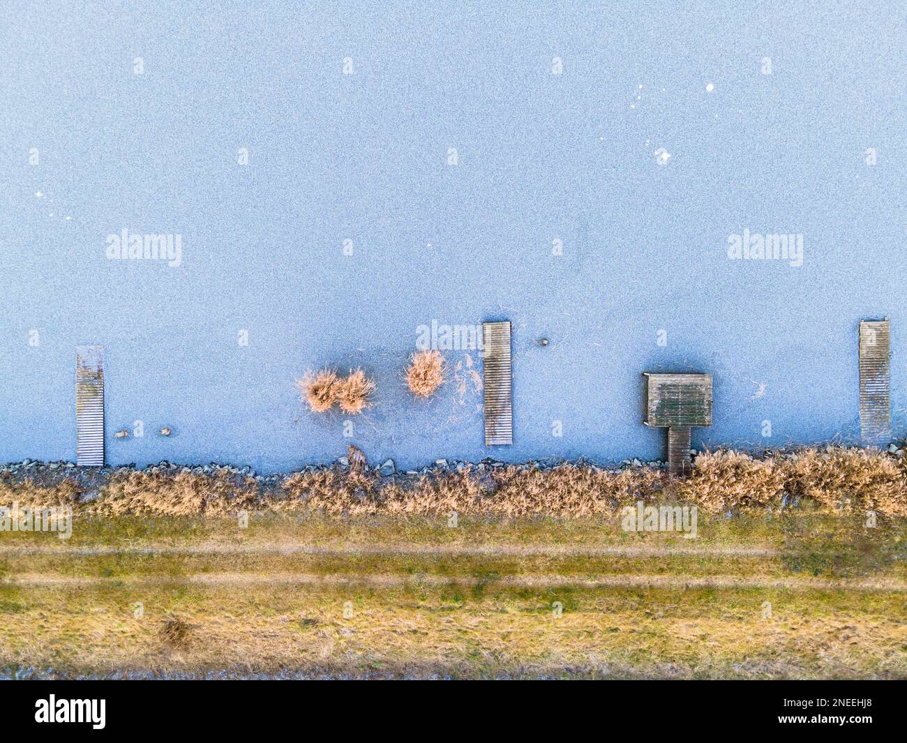 Luftaufnahme des Ufers eines gefrorenen Sees mit eisigen Piers, Terény, Ungarn Stockfoto