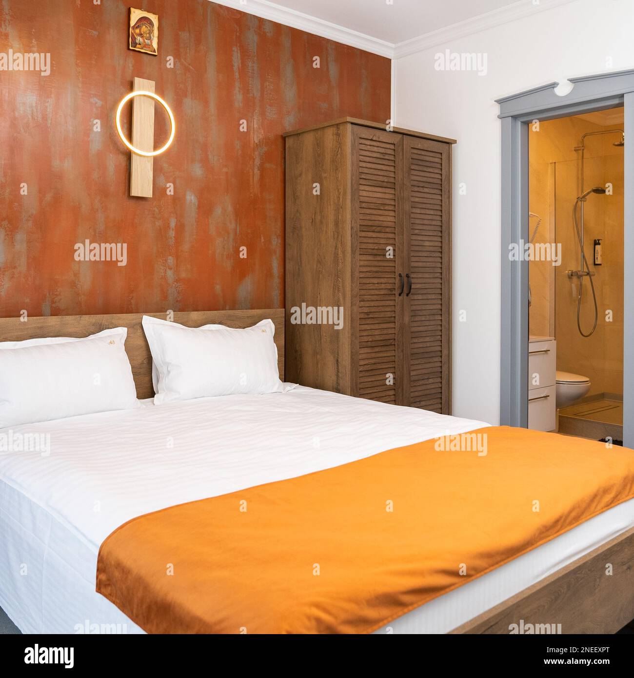 Moderne Einrichtung eines Hotelzimmers mit Holzgarderobe und Doppelbett Stockfoto