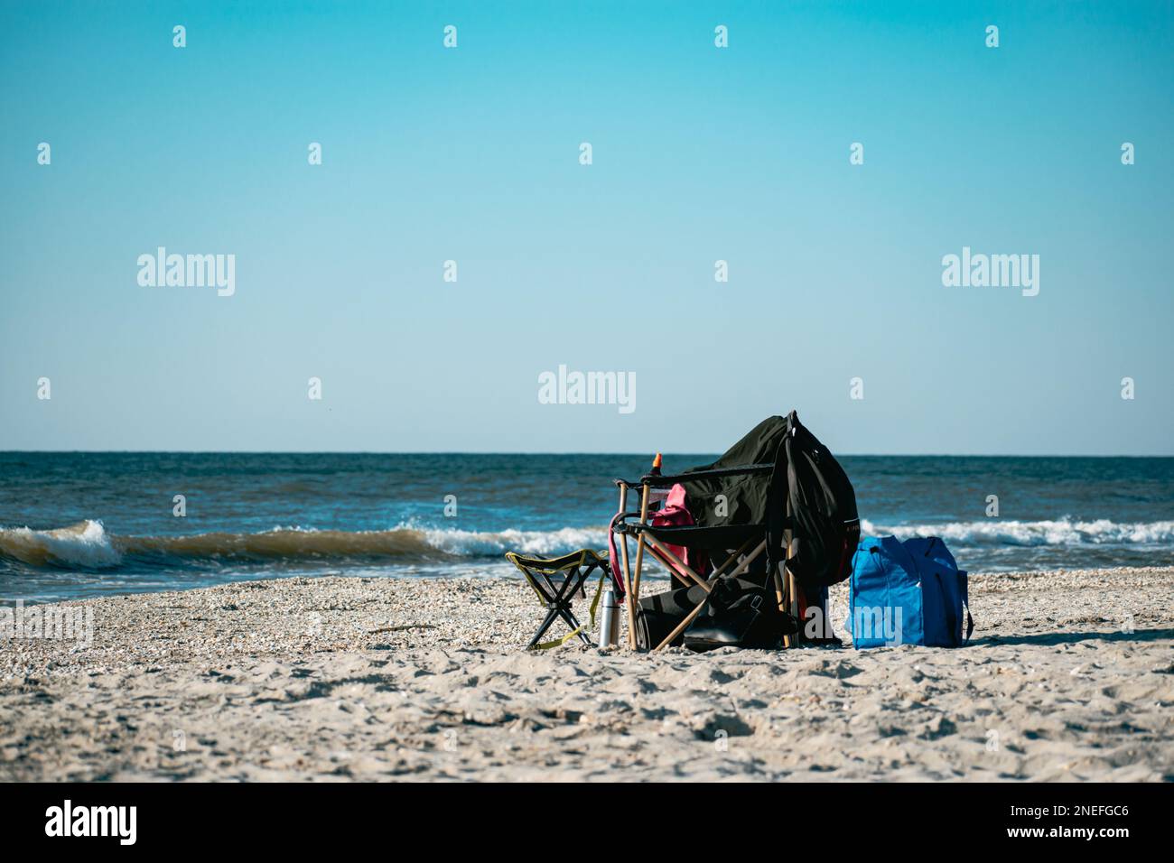 Ein leerer Liegestuhl am Strand mit Tasche und Kleidung. Sommerurlaub,  entspannend Stockfotografie - Alamy