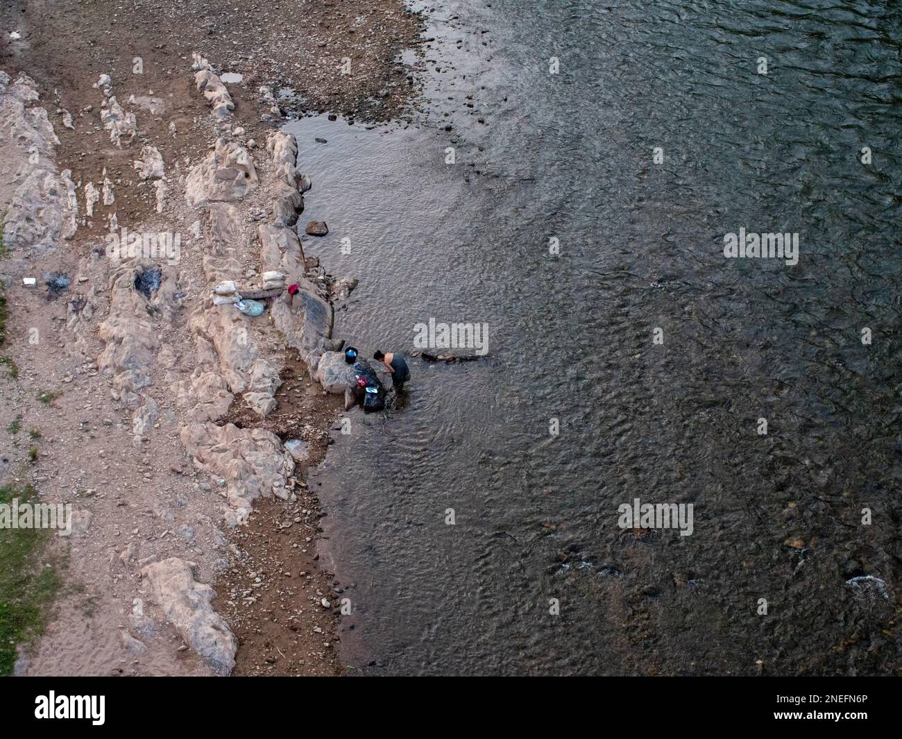 Eine Frau wäscht und badet im Nam Ou River in Muang Khua, Laos. Stockfoto