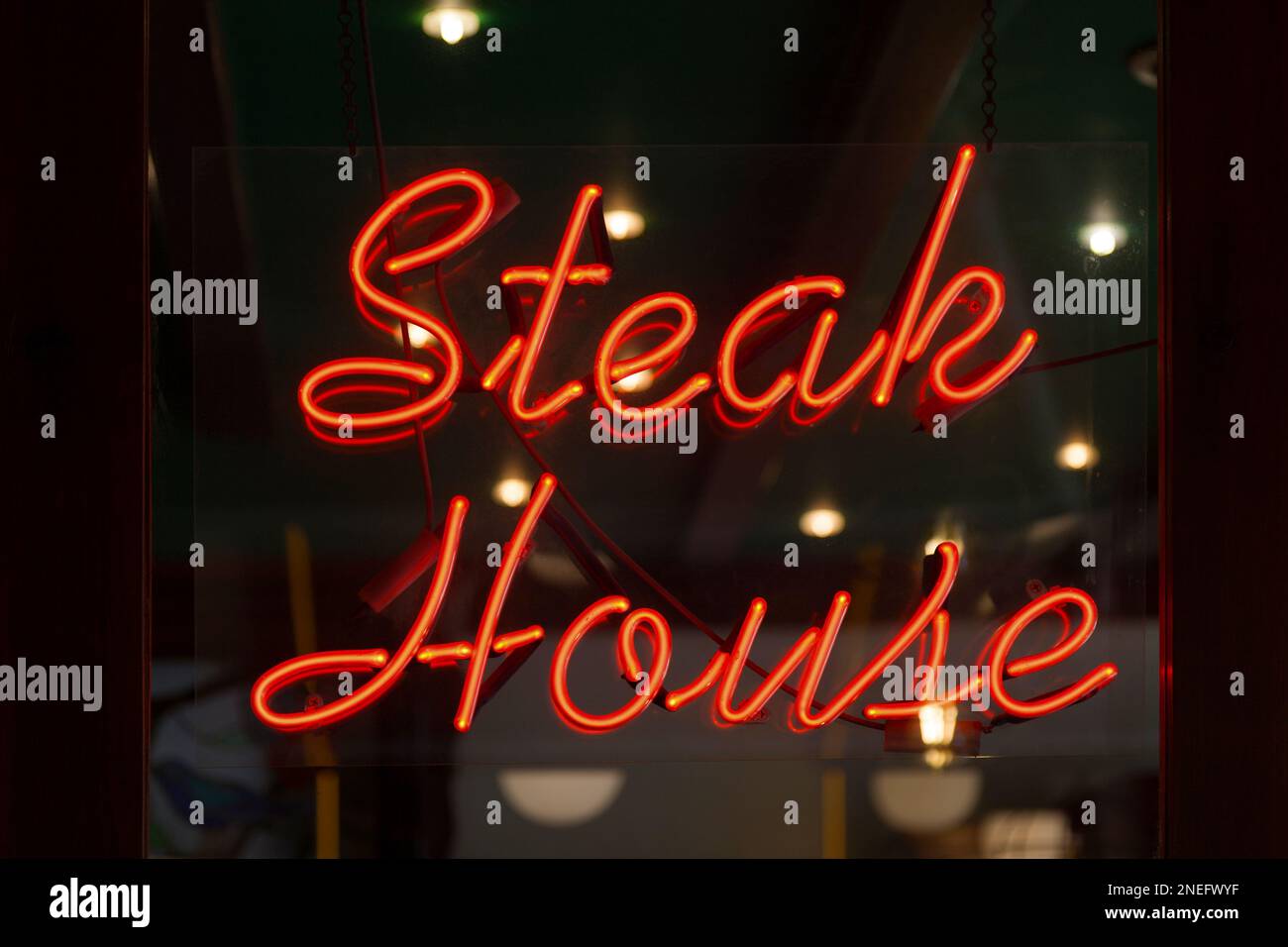 Rotes Neonlicht in Form der Worte „Steakhaus“. Stockfoto
