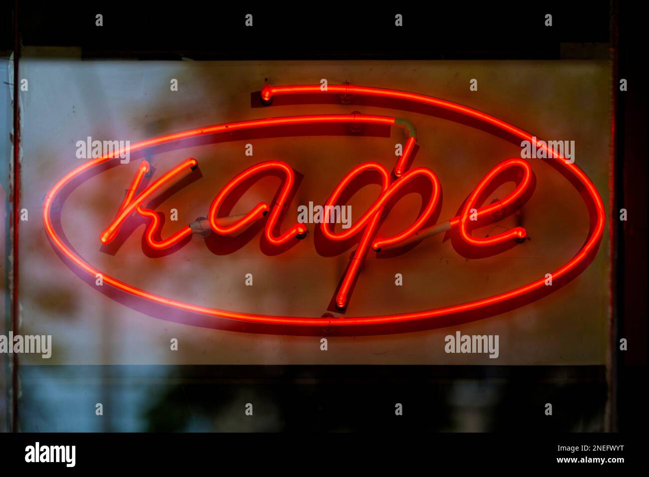 Nahaufnahme eines roten Neonlichts in Form des russischen Wortes „Kaфe“, was auf Englisch „Café“ bedeutet. Stockfoto