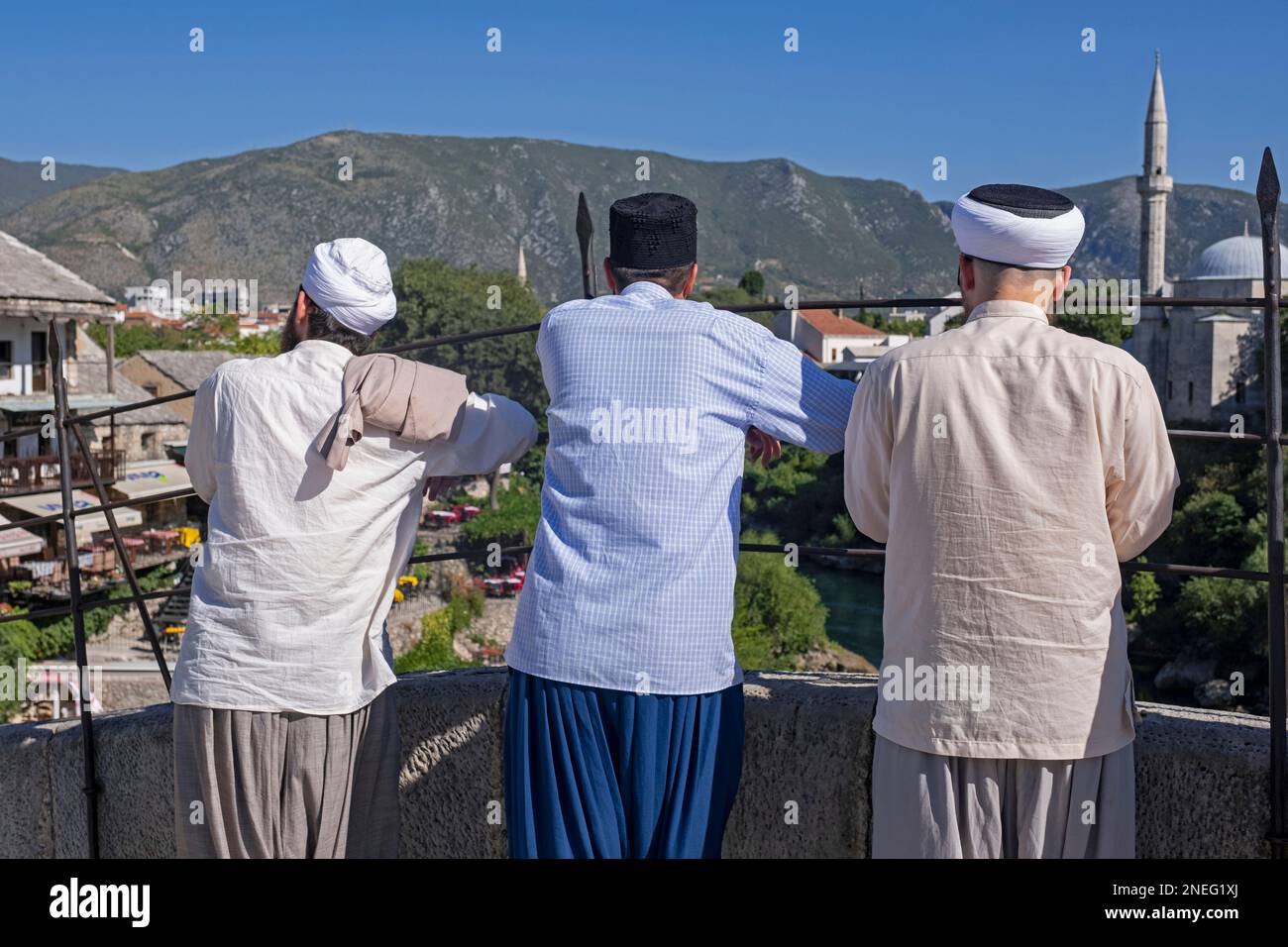 Drei muslimische Männer auf der Stari Most, osmanische Brücke aus dem 16. Jahrhundert in der Stadt Mostar, Kanton Herzegowina-Neretva, Bosnien und Herzegowina Stockfoto